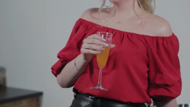 Bella giovane donna con un bicchiere di succo in cucina . — Video Stock