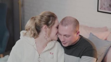 Güzel ve genç bir adam ve bir kadın yatakta sarılıyorlar..