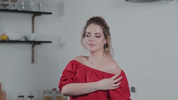 Hermosa joven con un vaso de jugo en la cocina . — Vídeos de Stock