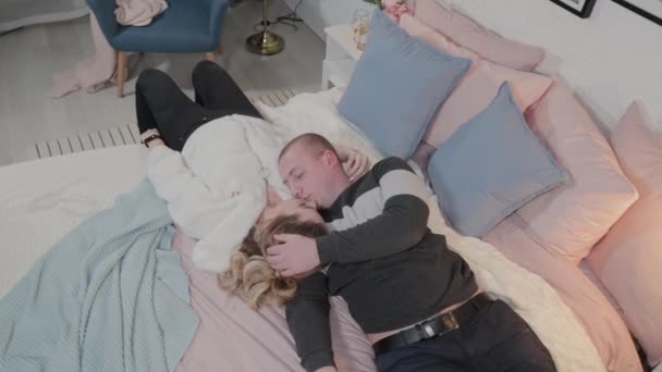 Bonito e jovem homem e mulher abraçando na cama . — Vídeo de Stock