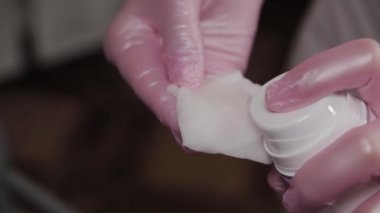 Profesyonel güzellik uzmanı pamuk pedleri nemlendiriyor.