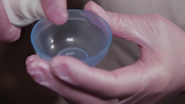 Professional beautician pours mask into a container for stirring. — Stock Video