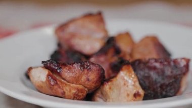 Man removes skewers from skewers on a plate.