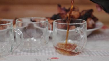 Beer is poured into glasses on the table with meat.