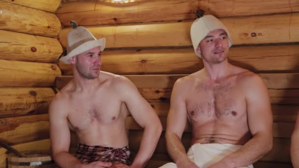 Knappe fysiek ontwikkelde mannen zweven in de sauna. — Stockvideo