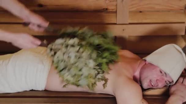 Atletische mannen zweven in een sauna met bezems. — Stockvideo