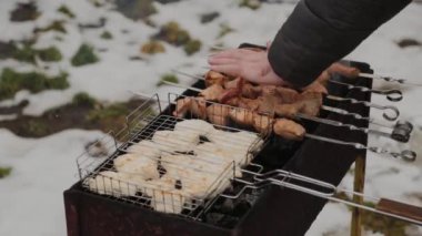 The process of cooking barbecue on fire in winter weather on a background of snow.