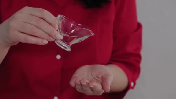 Γυναίκα θεραπεύτρια μασάζ χύνει λάδι μασάζ στο χέρι. — Αρχείο Βίντεο