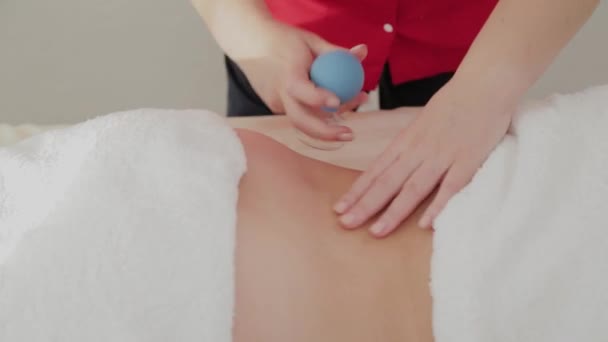 Professional massage therapist makes therapeutic massage with banks. — Stock Video