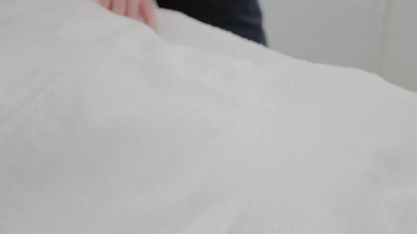 Mulher massagem terapeuta levanta uma toalha no estômago da menina . — Vídeo de Stock