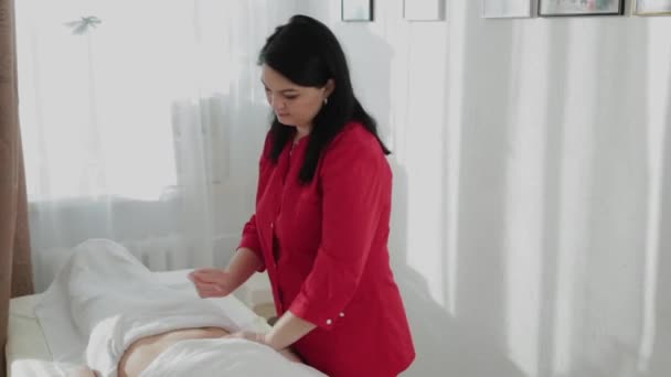 Mujer terapeuta de masaje hace masaje en el estómago de una niña . — Vídeo de stock