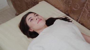 Güzeller güzeli genç kız bir güzellik salonunda kanepede.