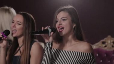 Karaoke kulübünde şarkı söyleyen güzel genç kızlar.