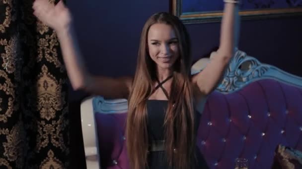 Ung flicka sjunger i en mikrofon på en soffa i en karaokeklubb. — Stockvideo
