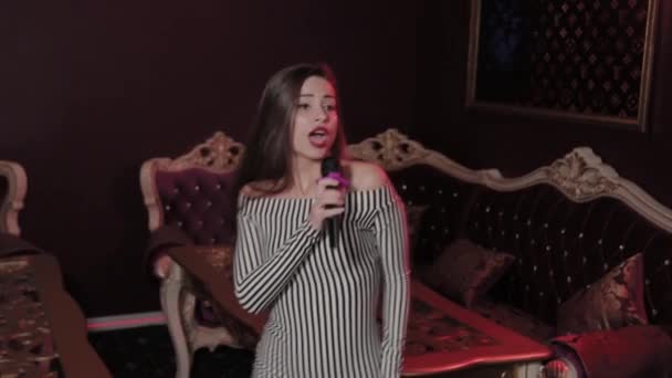 Junges schönes Mädchen singt im Karaoke. — Stockvideo