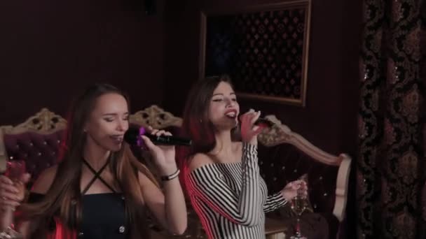 Hermosas chicas jóvenes cantando en el club de karaoke . — Vídeos de Stock