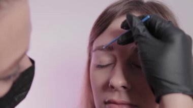 Kadın usta müşteriye kaşlarını boyuyor..
