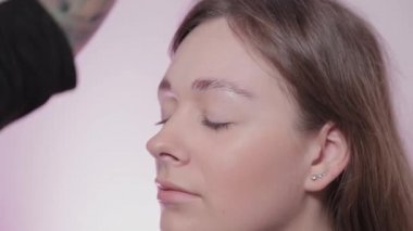 Kadın usta müşteriye kaşlarını boyuyor..