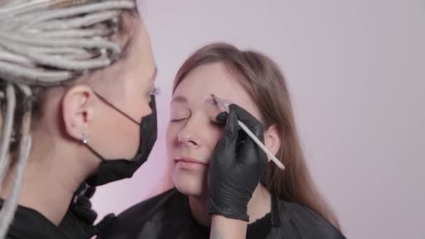 Woman master paints eyebrows to client. — Stock Video