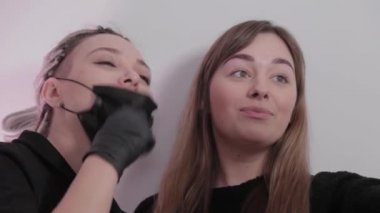 Makyaj sanatçısı ve müşteri kızı ameliyattan sonra güzellik salonunda selfie çekiyorlar..
