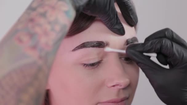 Жінка майстер малює брови клієнту . — стокове відео