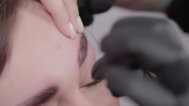Maquilleur professionnel arrachant les sourcils au client au salon de beauté . — Video