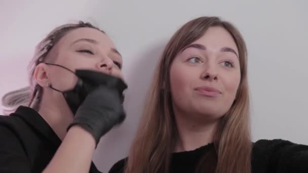 Mulher make-up artista e cliente menina tirar uma selfie em um salão de beleza após o procedimento . — Vídeo de Stock