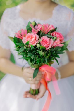 Young happy bride with a wedding bouquet by a bouquet.