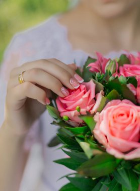 Young happy bride with a wedding bouquet by a bouquet.