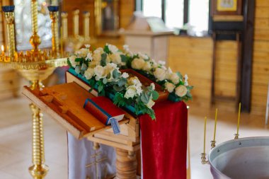 Red Bible in a church with a cross on a stand.