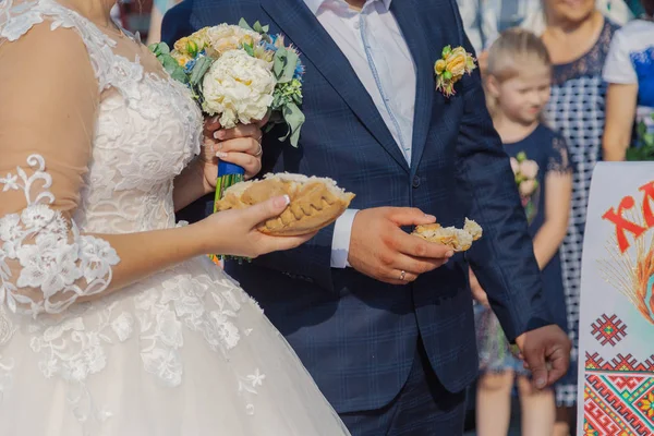 Happy newlyweds with bread and salt in their hands. — Stock Photo, Image