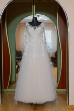 Beautiful wedding dress on a hanger on a happy wedding day.