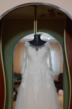 Beautiful wedding dress on a hanger on a happy wedding day.