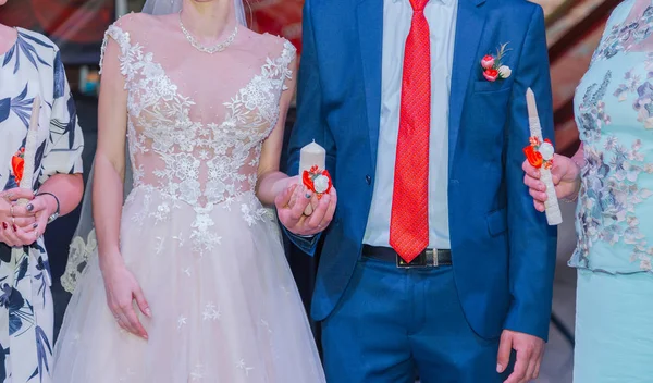 Mooie pasgetrouwden steken een kaars aan op een huwelijksfeest. — Stockfoto