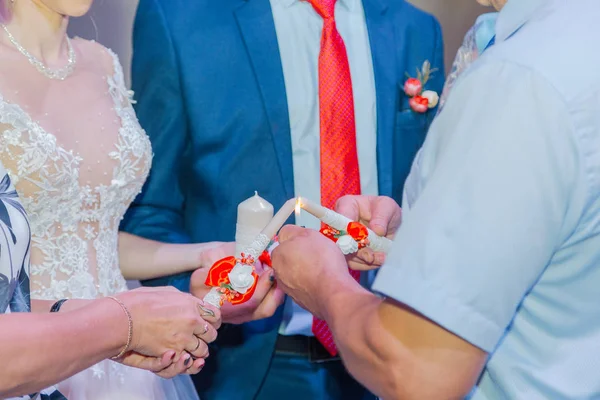 Pengantin baru yang indah menyalakan lilin pada perayaan pernikahan . — Stok Foto