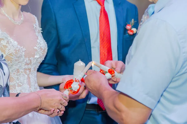 Beautiful newlyweds light a candle at a wedding celebration. — Stok fotoğraf