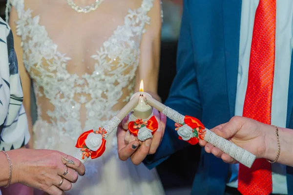 Красиві молодята запалюють свічку на весільному торжестві . — стокове фото