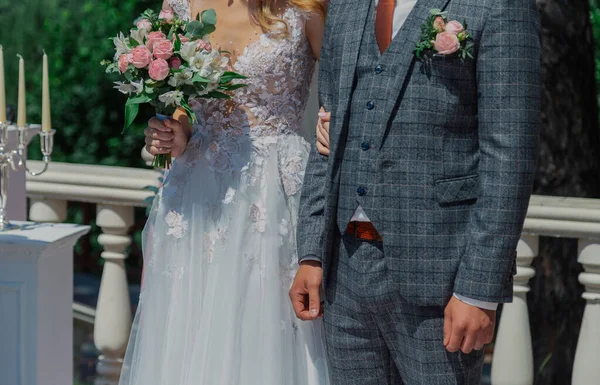 Jonge gelukkige bruid met een bruiloft boeket door een boeket. — Stockfoto