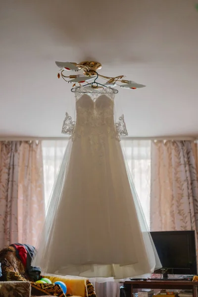Hermoso vestido de novia en una percha en un feliz día de la boda . —  Fotos de Stock