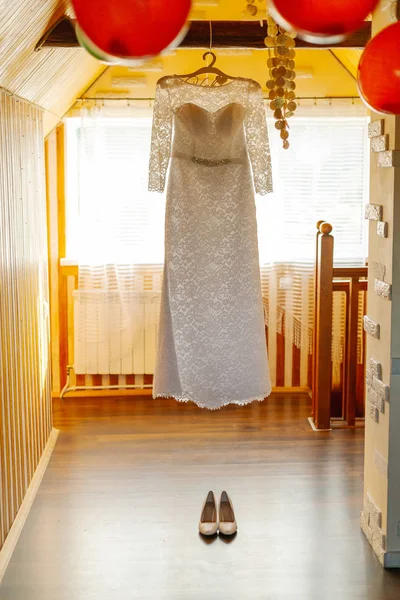 Hermoso vestido de novia en una percha en un feliz día de la boda . — Foto de Stock