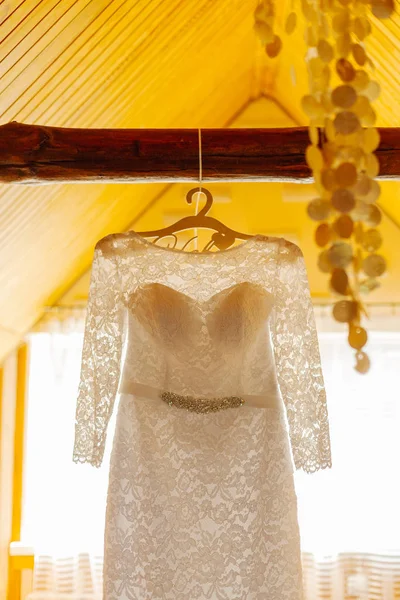 Hermoso vestido de novia en una percha en un feliz día de la boda . —  Fotos de Stock