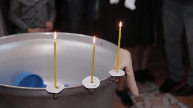 Ortodoks Kilisesinde mum yakan bebeklerin vaftiz yazı tipleri..