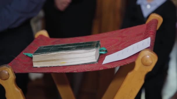 Christliche Bibel liegt auf einem Ständer in einer Kirche. — Stockvideo