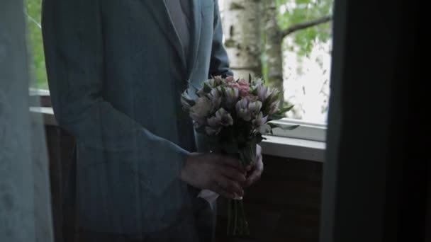 Un giovane uomo con un bouquet da sposa in mano . — Video Stock