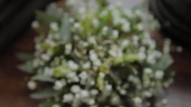 Golden wedding rings on flowers close-up.