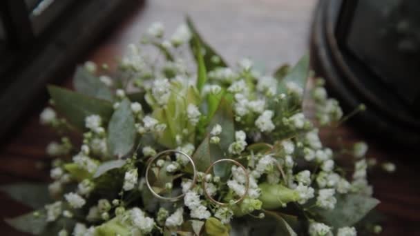 Golden wedding rings on flowers close-up. — 图库视频影像