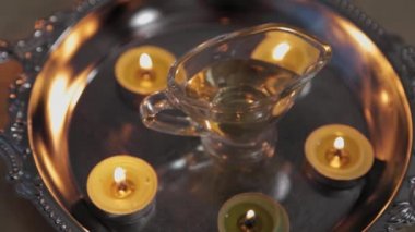 Burning candles on a couch in a massage parlor. Vessel with massage oil.