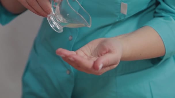 Mujer masajista terapeuta derrama aceite de masaje en la mano . — Vídeos de Stock