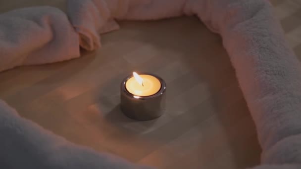 Queimar velas em um sofá em uma sala de massagem . — Vídeo de Stock