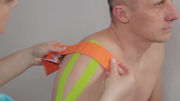Doktor přilepí speciální léčebnou pásku k muži.. — Stock video